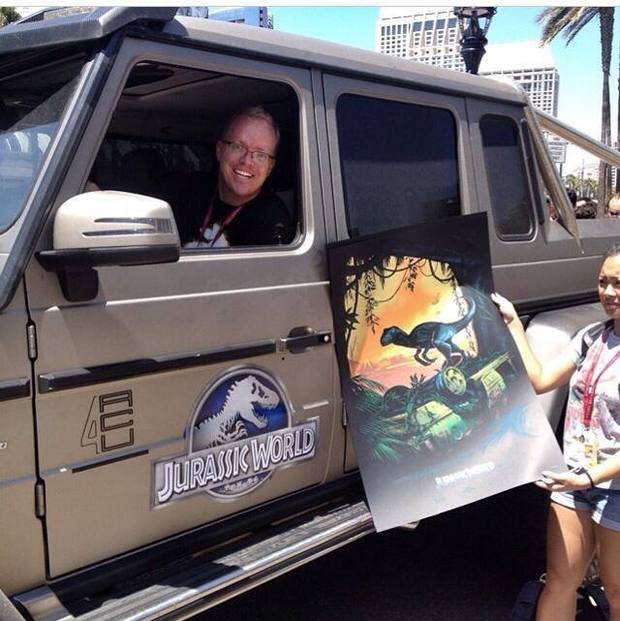 Un afortunado asistente montando al vehiculo y con su poster de regalo