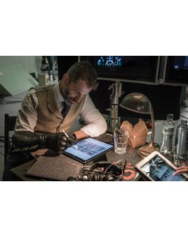 Zack Snyder con unos bocetos de la Liga de la Justicia (con un tío con parche y espadas posiblemente hablando con un tipo sin pelo) 